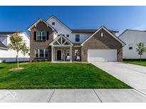 Beautiful two-story home featuring manicured lawn, gray brick, and a welcoming front porch at 628 Tess Blvd, Westfield, IN 46074