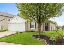 Charming single-Gathering home with a well-manicured lawn and a mature shade tree in the front yard at 671 Greenway St, Greenwood, IN 46143
