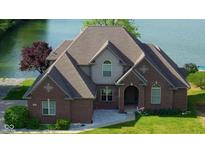 Charming brick two-story home features a well-maintained lawn and stunning waterfront views, ideal for serene lakeside living at 719 E New Rd, Greenfield, IN 46140
