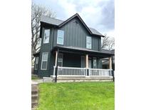 Inviting two-story home with a charming front porch and well-maintained lawn at 909 N Temple Ave, Indianapolis, IN 46201