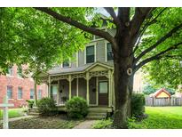 Charming two-story home with a cozy front porch and mature trees, providing a welcoming curb appeal at 925 Fayette St, Indianapolis, IN 46202