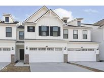 New construction townhome featuring white siding, black shutters, and attached two car garage at 9741 Oleander Dr, Fishers, IN 46250