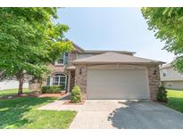 Charming two-story brick home with a well-maintained lawn and mature trees under a clear sky at 977 Canary Creek Dr, Franklin, IN 46131