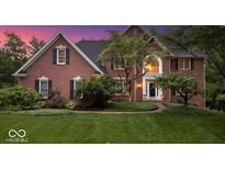 Charming red brick home with manicured lawn and lush landscaping at 11227 Woods Bay Ln, Indianapolis, IN 46236