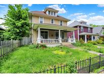 Charming two-story home featuring a welcoming front porch, well-maintained lawn, and classic architectural details at 1138 N Oxford St, Indianapolis, IN 46201
