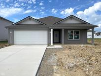 Charming single-story home with a gray exterior, a pristine white garage door, and a concrete driveway at 1170 Mcbride St, Greenfield, IN 46140