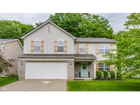 Two-story home with light siding, wooden shutters, brick accents, and a manicured front yard at 11919 Gatwick View Dr, Fishers, IN 46037