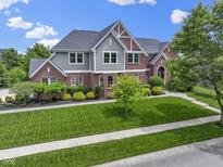 Beautiful two-story home featuring a manicured lawn, brick facade, and mature landscaping at 11984 Talnuck Cir, Fishers, IN 46037