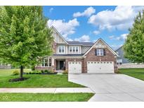 Beautiful two-story brick home with attached two car garage, manicured lawn, and mature shade tree at 14931 W Black Wolf Run Dr, Carmel, IN 46033