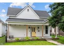 Charming home featuring a cheerful yellow front door, porch and well-maintained front lawn at 1627 Pleasant St, Indianapolis, IN 46203