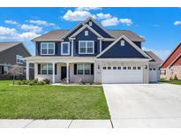 Beautiful two-story home showcasing a well-manicured lawn, white brick accents, and a spacious three-car garage at 1704 Beach St, Greenwood, IN 46143