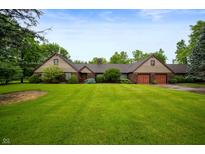 Ranch home with brick facade, attached garage and lush green lawn at 2411 N County Road 500 W, Muncie, IN 47304