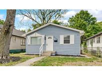 Charming blue house featuring a white front door and well-maintained landscaping at 3106 N Harding St, Indianapolis, IN 46208