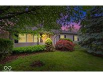 Charming single-story home featuring a lush front yard with mature trees and colorful landscaping at 3801 N Vernon Dr, Muncie, IN 47304