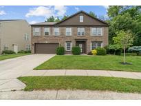 Traditional two-story brick home with a well-maintained lawn and attached two car garage at 5640 High Vista Cir, Indianapolis, IN 46234