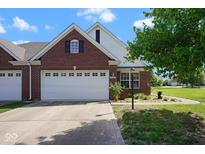 Charming brick home featuring a manicured lawn, a two-car garage, and tasteful landscaping at 6105 Franklin Villas Way, Indianapolis, IN 46237