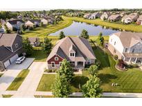 Beautiful home boasts manicured lawn, mature trees, and a serene pond view at 6337 Ederline Ln, Noblesville, IN 46062