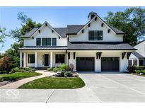 Charming two-story home featuring a black roof, white painted brick, and a two car garage at 6450 Holliday E Dr, Indianapolis, IN 46260