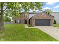 Charming brick home with a two-car garage and a green lawn at 65 Millet Ct, Danville, IN 46122
