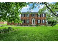Charming two-story brick home with manicured lawn and mature trees offering a welcoming curb appeal at 6838 Five Points Rd, Indianapolis, IN 46259
