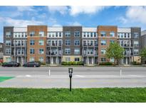 Modern apartment building with brick facade, balconies, and manicured landscaping at 727 N Illinois St # 202, Indianapolis, IN 46204