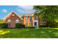 Charming brick home with a well-manicured lawn, mature trees and a beautiful facade at 734 Richland Way, Westfield, IN 46074