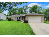 Charming single-story brick home with a well-maintained lawn and attached two car garage at 9002 Walton St, Indianapolis, IN 46231