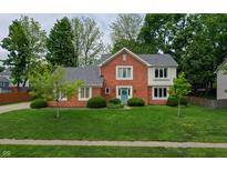 Charming brick two-story home features a well-manicured lawn and mature trees in a desirable neighborhood at 1004 Nevelle Ln, Carmel, IN 46032