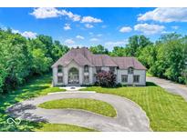 Stunning two-story home with a circular driveway and beautifully landscaped front yard at 11575 Freeport Dr, Carmel, IN 46032