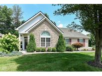 Charming stone home featuring a well-manicured lawn and established landscaping at 11692 Seven Oaks Dr, Fishers, IN 46038