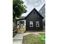 Newly renovated two-story home showcasing a black and white color scheme with new windows and wood porch at 1318 Hoyt Ave, Indianapolis, IN 46203