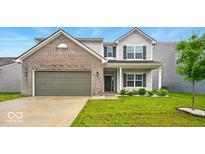 Charming two-story home featuring a brick facade, attached garage, and well-manicured front lawn at 1454 Silver Pine Ln, Sheridan, IN 46069