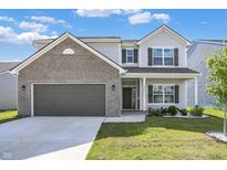 Charming two-story home with a well-manicured lawn, attached garage and a mix of brick and siding exterior at 1454 Silver Pine Ln, Sheridan, IN 46069