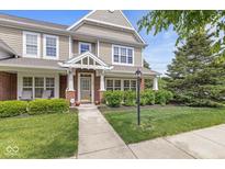 Charming two-story home with a well-manicured lawn and inviting front porch with brick and shake siding at 15421 Bowie Dr, Westfield, IN 46074