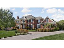 Elegant brick home featuring manicured landscaping and a circular driveway at 24 Shannon Rd, Zionsville, IN 46077