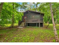 Charming home exterior with a red door, quaint porch, and nestled among mature trees at 2781 E Vandalia Rd, Flat Rock, IN 47234