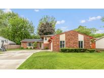 Charming front exterior showcasing a well-manicured lawn and brick facade, with a basketball hoop on the side at 3514 Summerfield Dr, Indianapolis, IN 46214