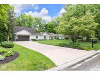 Charming single-story home featuring a manicured lawn, long driveway, and inviting curb appeal at 445 W 63Rd St, Indianapolis, IN 46260