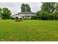 Traditional two-story home with a large front lawn and mature landscaping, including a flower bed at 5135 Moller Rd, Indianapolis, IN 46254