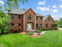 Two-story brick home with a manicured front yard and inviting entryway with beautiful landscaping at 5313 Redbird Dr, Columbus, IN 47201