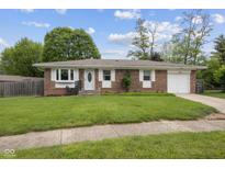 Charming brick home with a well-manicured lawn, attached garage, and inviting front entrance at 5326 Brazos Dr, Indianapolis, IN 46237