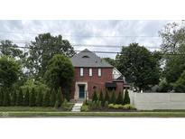 Charming brick home with a peaked roof, and manicured landscaping enhancing its curb appeal at 5401 N New Jersey St, Indianapolis, IN 46220