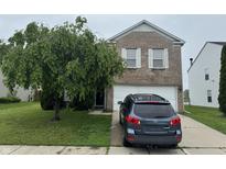 Charming two-story brick home with a well-manicured front yard and attached two-car garage at 5502 Floating Leaf Dr, Indianapolis, IN 46237
