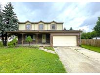 Charming two-story home featuring a covered front porch, attached garage, and well-maintained lawn at 5760 Tim Tam Ct, Indianapolis, IN 46237
