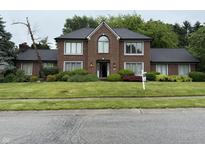 Charming brick two-story home features a well-manicured lawn and beautiful landscaping at 6609 N Tuxedo Ln, Indianapolis, IN 46220