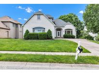 Charming white brick home featuring a well-manicured lawn and a paved driveway leading to the entrance at 6610 Royal Oakland Dr, Indianapolis, IN 46236