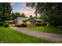 Charming one-story home with well-maintained lawn, brick facade, covered car port, and picturesque curb appeal at 7482 W Us Highway 40, Indianapolis, IN 46229