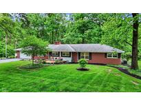 Charming brick ranch with well-maintained landscaping and inviting curb appeal in a serene, wooded setting at 8641 Cholla Rd, Indianapolis, IN 46240