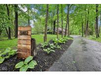 Long driveway leading to home, address displayed on wooden placard, lined with mulch and foliage at 8802 W 86Th St, Indianapolis, IN 46278