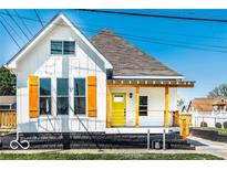 Charming home with a bright yellow front door, wooden shutters, and welcoming front porch at 918 S State Ave, Indianapolis, IN 46203